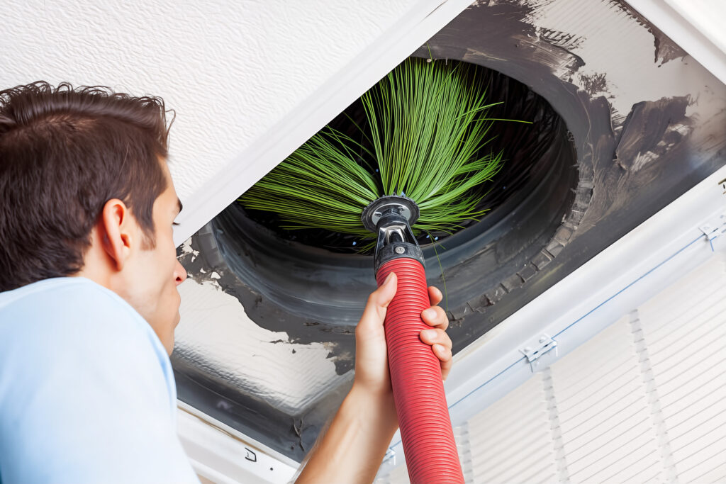 man cleaning air ducts in home.
